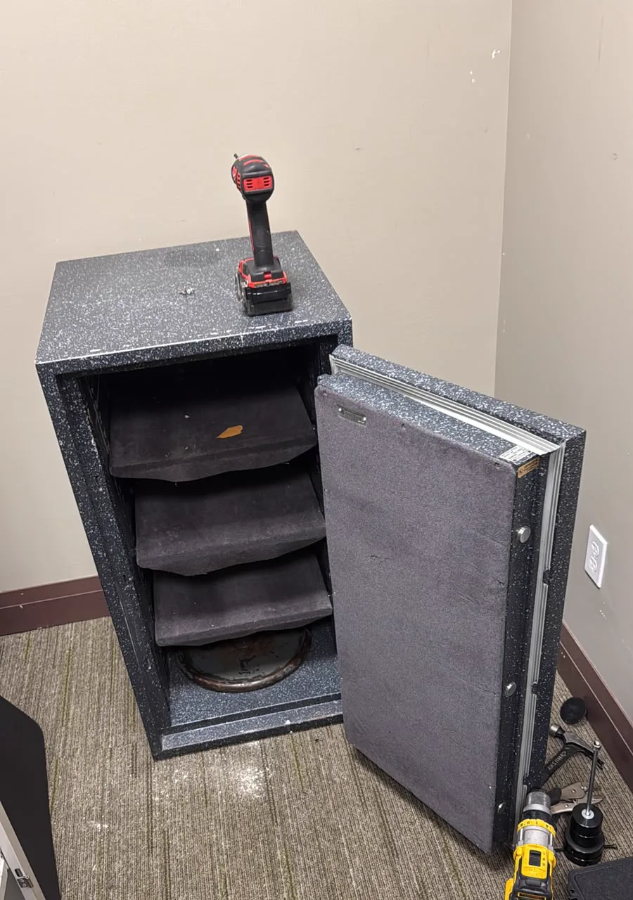 Safe door standing open after a professional drilled opening